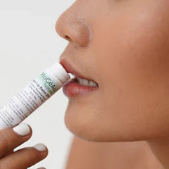 Close-up of a person applying natural lip balm for soft, nourished lips.