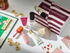 Make-up collection featuring skincare products, a box labeled 'The Prep and Set Edit', and playing cards.